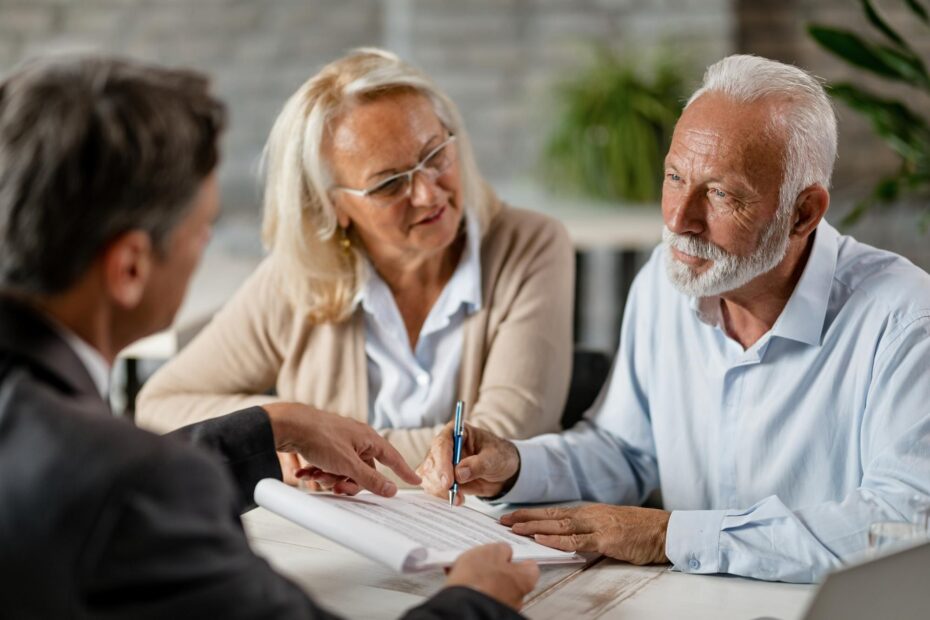 Pareja de adultos mayores negociando la financiación de un auto usado.