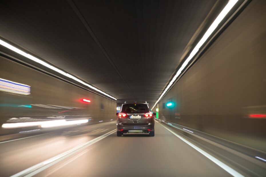 auto pasando un túnel con luces encendidas.
