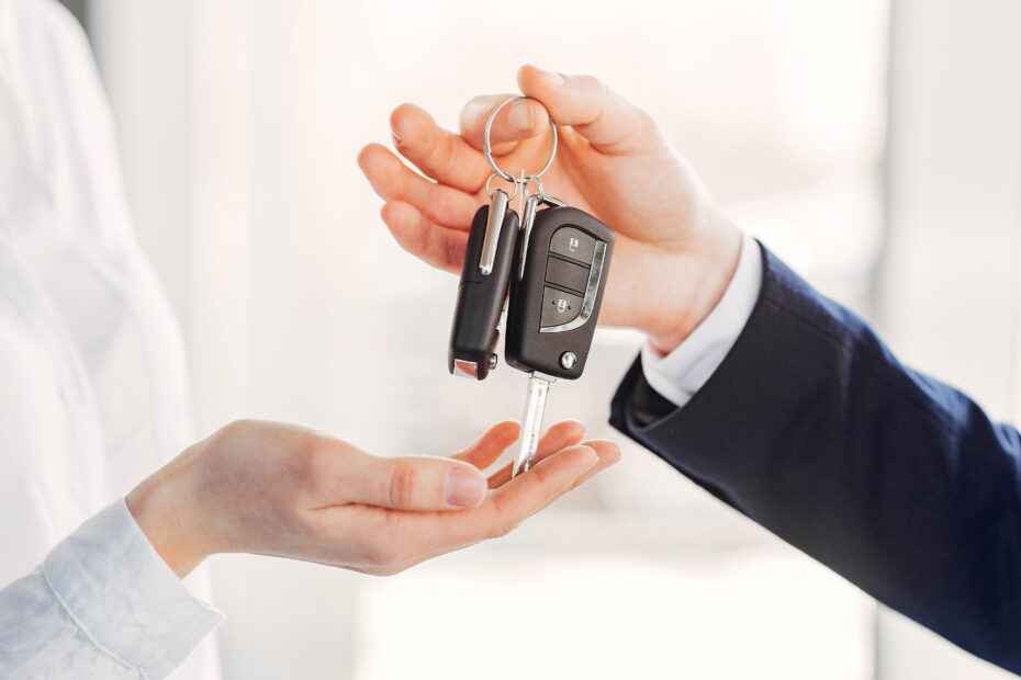 Personas cerrando compra de un auto usado