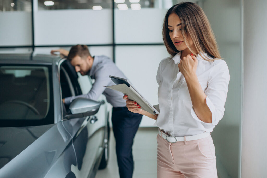 Mujer analizando guía para comprar auto usado.