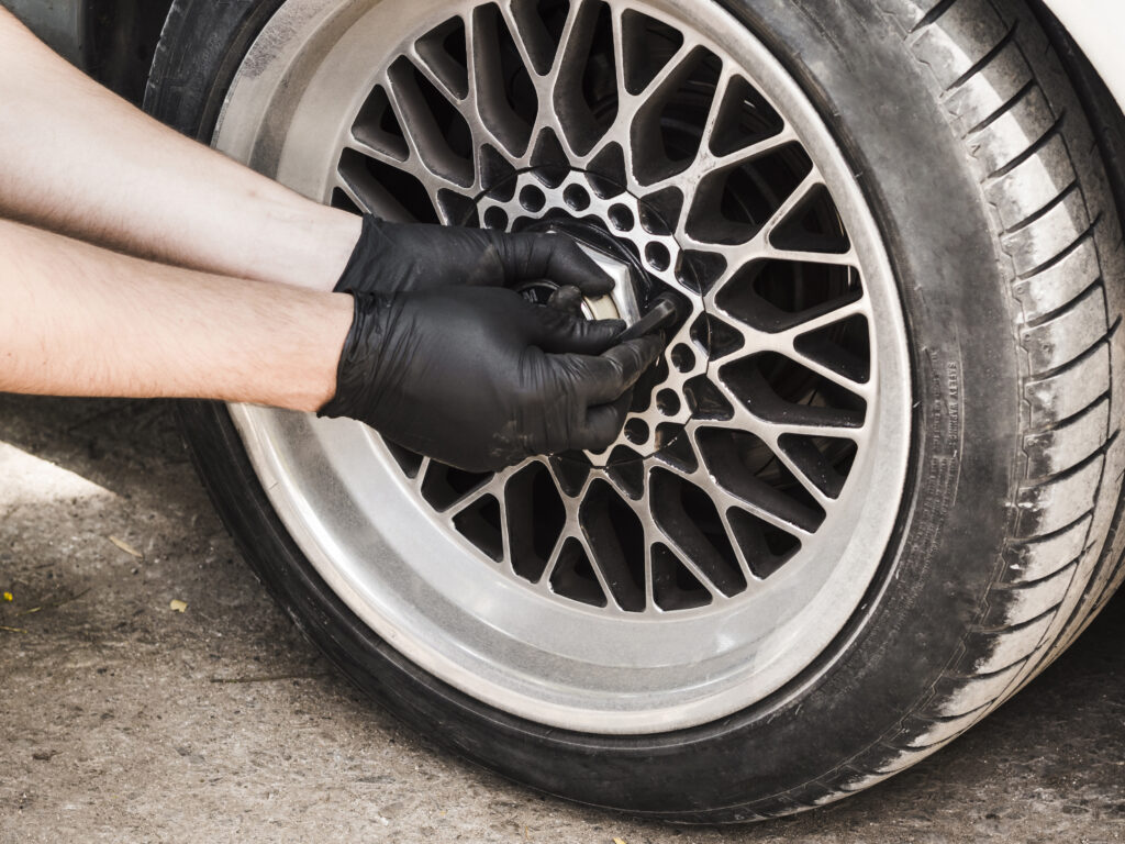 Persona arreglando neumáticos del auto.