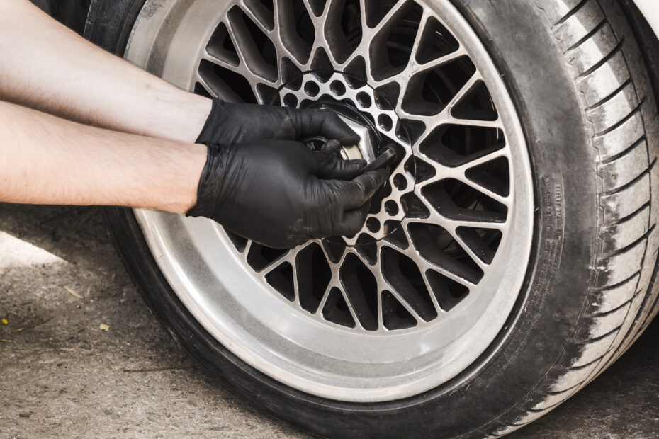 Persona arreglando neumáticos del auto.