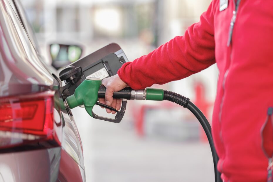 Un empleado de una estación de servicio carga combustible en un auto